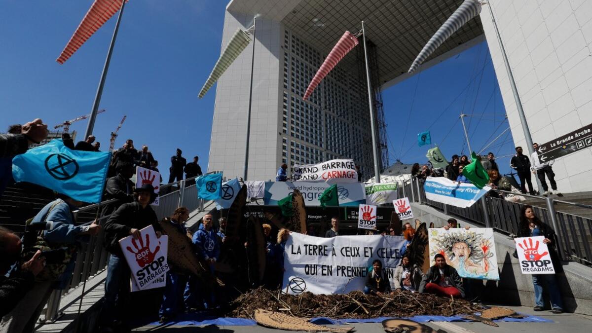 Activists of 'Extinction Rebellion' (XR) and NGO 'Planete Amazone' stage a protest against large hydroelectric dams in front of the Grande Arche de La Defense in Puteaux, northwest of Paris, on May 14, 2019, on the occasion of the 2019 World Hydropower Congress. The congress is held in Paris from May 14 to 16. FRANCOIS GUILLOT / AFP
