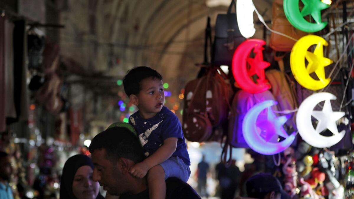 Palestinians walk past shops decorated ahead of the Muslim holy fasting month of Ramadan, in Jerusalem's old city on May 2, 2019.  AHMAD GHARABLI / AFP