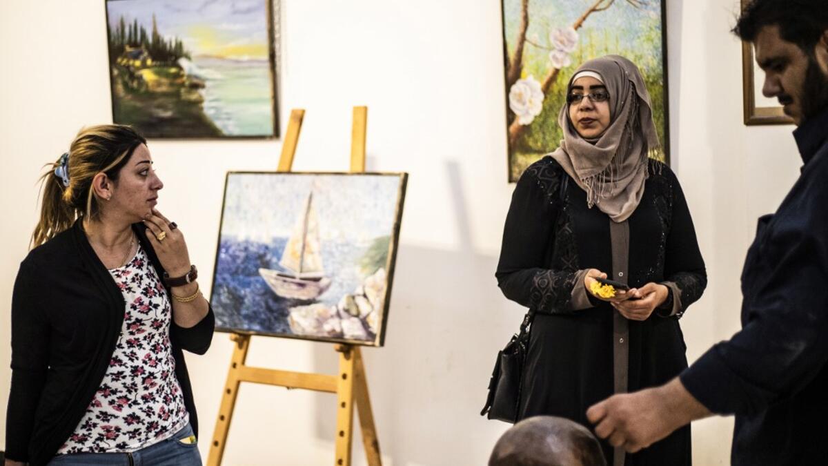 Residents of the eastern Syrian city of Raqa view artworks during an exhibition at the first cultural centre to open since ISIS rule ended there, on May 1, 2019. DELIL SOULEIMAN / AFP