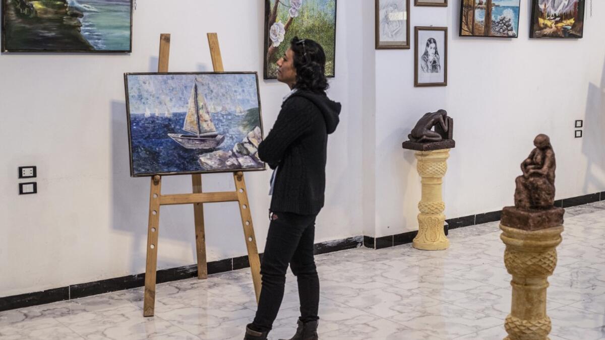 Amal al-Attar, a 37-year-old artist, looks at her artworks on display during an exhibition at the first cultural centre to open since ISIS rule ended in the eastern Syrian city of Raqa on May 1, 2019. DELIL SOULEIMAN / AFP