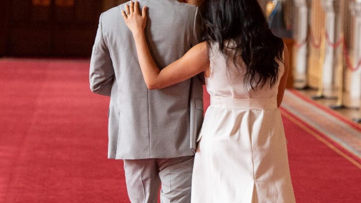 Britain's Prince Harry, Duke of Sussex (L), and his wife Meghan, Duchess of Sussex, walk away after posing for photographs with their newborn baby son, Archie Harrison Mountbatten-Windsor, in St George's Hall at Windsor Castle in Windsor, west of London on May 8, 2019.  Dominic Lipinski / POOL / AFP